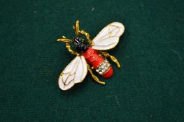 A gilt metal, enamel decorated bee brooch.