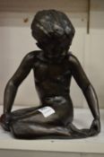 A filled bronze model of a seated female.