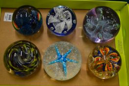 Six glass paperweights.