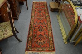 A Persian design runner, rust ground with stylised decoration 254cm x 66cm.