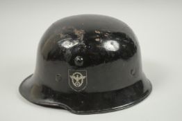 A NAZI GERMAN BLACK STEEL HELMET WITH POLICE DECAL.
