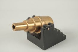 A MODEL COASTAL DEFENCE BRASS GUN on a steel base. 16cm.