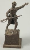 A CAST BRONZE OF A WWI SOLDIER. Signed, 15cm high.