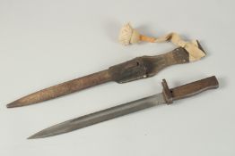A WW1 GERMAN VOLUSTER BAYONET in a metal sheath and leather pommel.