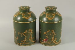 A PAIR OF GREEN TOLEWARE CIRCULAR CANNISTERS AND COVERS. 34cm high.