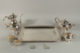 A TWO HANDLED SILVER PLATED TEA TRAY, A THREE PIECE TEA SET, sugar basin and milk jug, and two
