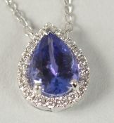 AN 18CT WHITE GOLD PEAR SHAPED TANZANITE AND DIAMOND CLUSTER PENDANT on an 18ct white gold chain,