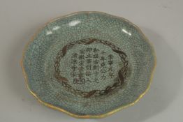 A CHINESE CELADON CRACKLE GLAZE DISH with incised characters. 21cm wide.