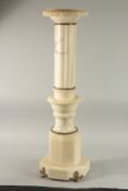 A CARVED ALABASTER PEDESTAL with circular top, fluted and carved stepped column on an octagonal base