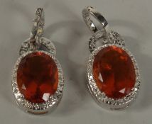A PAIR OF SILVER ORANGE STONE DROP EARRINGS.