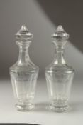 A PAIR OF TAPERING GLASS DECANTERS AND STOPPERS.