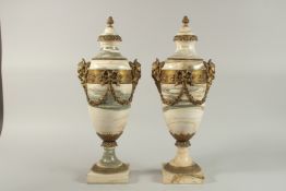 A GOOD PAIR OF VEINED MARBLE AND ORMOLU CASSOLETTES with ram's mask mounts, ribbons and floral
