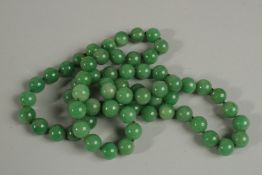 A GOOD STRING OF SIXTY SIX GREEN JADE BEADS. 80cm long.