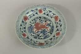 A CHINESE BLUE AND WHITE AND RED UNDER GLAZE PORCELAIN CHARGER, decorated with central panel