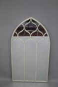A WHITE METAL ARCHED MIRROR 124cm high, 61cm wide.