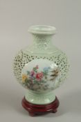 A CHINESE CELEDON GLAZE FAMILLE ROSE OPENWORK PORCELAIN VASE on a stand, with pierced isne pattern