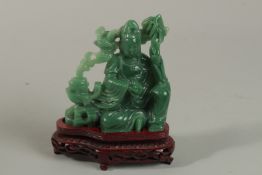 A CHINESE GREEN STONE FIGURE on a stand.
