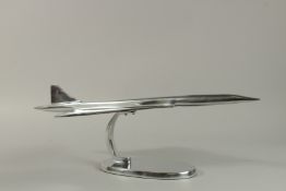 A LARGE CHROME MODEL OF CONCORDE on an oval base. 60cm long.