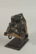 A MINERAL SPECIMAN, black crystal, 16cm high on a stand.