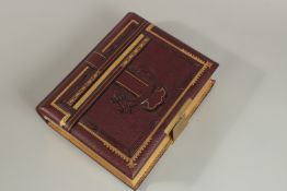 A VICTORIAN MUSICAL LEATHER PHOTOGRAPH ALBUM with key. 30cm x 23cm