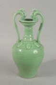 A GREEN GLAZED PORCELAIN TWIN HANDLED VASE, the handles formed as horse heads. 36cm high.