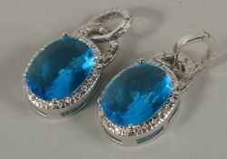 A PAIR OF SILVER BLUE STONE DROP EARRINGS.