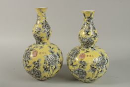 A PAIR OF CHINESE YELLOW GROUND PORCELAIN DOUBLE GOURD VASES with floral decoration. 32cm high.