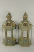 A SMALL PAIR OF BULBOUS METAL GLAZED LANTERNS. 45cms high.