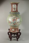 A CHINESE FAMILLE ROSE PORCELAIN FLOOR STANDING TABLE VASE on a hardwood stand, with moulded bat