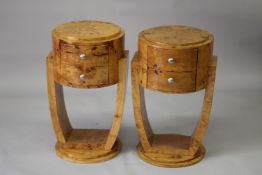 AN ART DECO DESIGN BLOND WOOD CIRCULAR BEDSIDE TABLES with two drawers and curving side supports.