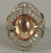 A .925 SILVER, DIAMANTE AND RED CARBOUCHON STONE RING.