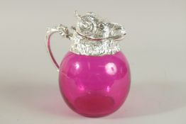 A GOOD RUBY GLASS NOVELTY CLARET JUG with ram's head, silver plated head and handle. 18cm high.