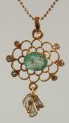 A FLORAL PENDANT IN YELLOW METAL SET WITH OVAL EMERALD MIXED CUT AND SLICE CUT DIAMONDS, on a gold