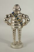 A GILT METAL STANDING MICHELIN MAN on a circular base. 34cms high.