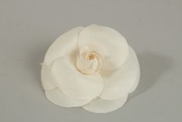 A CHANEL WHITE FABRIC FLOWER BROOCH. 10cm diameter in a Chanel box.