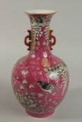 A CHINESE PINK GROUND PORCELAIN VASE decorated with a bird amongst flora. 33cm high.