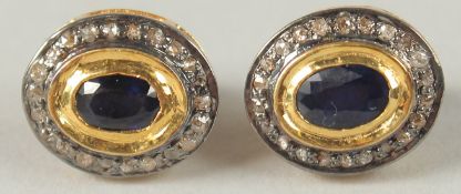 A PAIR OF OVAL SAPPHIRE AND R/C DIAMOND HALO STUD EARRINGS, set in gold plated silver, boxed.