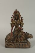 A GILT BRONZE DEITY seated upon a mythical beast. 33cm high.