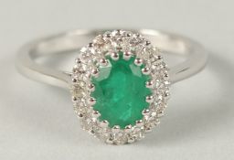 AN 18CT WHITE GOLD OVAL EMERALD AND DIAMOND CLUSTER RING. Emerald 1.31ct RBC diamonds 0.37ct.