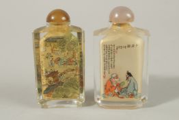 TWO CHINESE REVERSE GLASS PAINTED SNUFF BOTTLES, one very finely decorated with a busy village