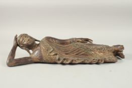 AN INDIAN CARVED WOOD RECLINING BUDDHA, with inset coloured glass to the robes, 59cm long.