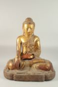 A VERY LARGE BURMESE GILT LACQUERED CARVED WOOD SEATED BUDDHA, with coloured glass inlays to the