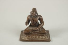 A SMALL 18TH-19TH CENTURY SOUTH INDIAN BRONZE FIGURE OF A TAMIL SAINT, seated in sattvasana, his