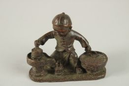 A BRONZE OKIMONO OF A BOY GRINDING COFFEE.
