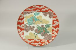 A FINE CHINESE RED GROUND PORCELAIN CHARGER, painted with central panel depicting two mythical