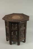 AN ANGLO INDIAN BRASS INLAID CARVED WOOD OCCASIONAL TABLE, with carved openwork folding legs.