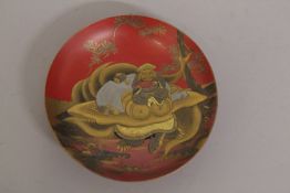 A FINE 19TH CENTURY JAPANESE MEIJI RED AND GILT LACQUER SAKE DISH, depicting a seated immortal