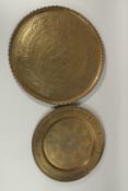 TWO ISLAMIC ENGRAVED BRASS TRAYS, largest 49cm diameter.
