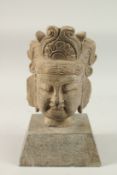 A CHINESE CARVED STONE HEAD WITH CEREMONIAL HEADPIECE, with square-form base, head 28cm high, base