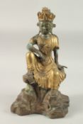 A CHINESE GILDED BRONZE SEATED FIGURE ON A ROCKY MOUND, 40cm high, base 24cm wide.